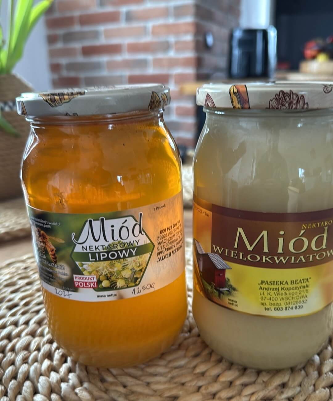 Kolorowe zdjęcie przedstawiające dwa Słoiki z miodem z etykietą oraz pieczątką lokalnego wytwórcy – pszczelarza.