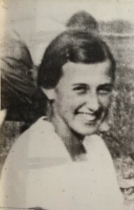 Portret młodej kobiety (Oleńka) Archiwalne czarno-białe zdjęcie młodej kobiety z krótką fryzurą, uśmiechniętej, w jasnym stroju. Fotografia o miękkim, lekko rozmytym charakterze.