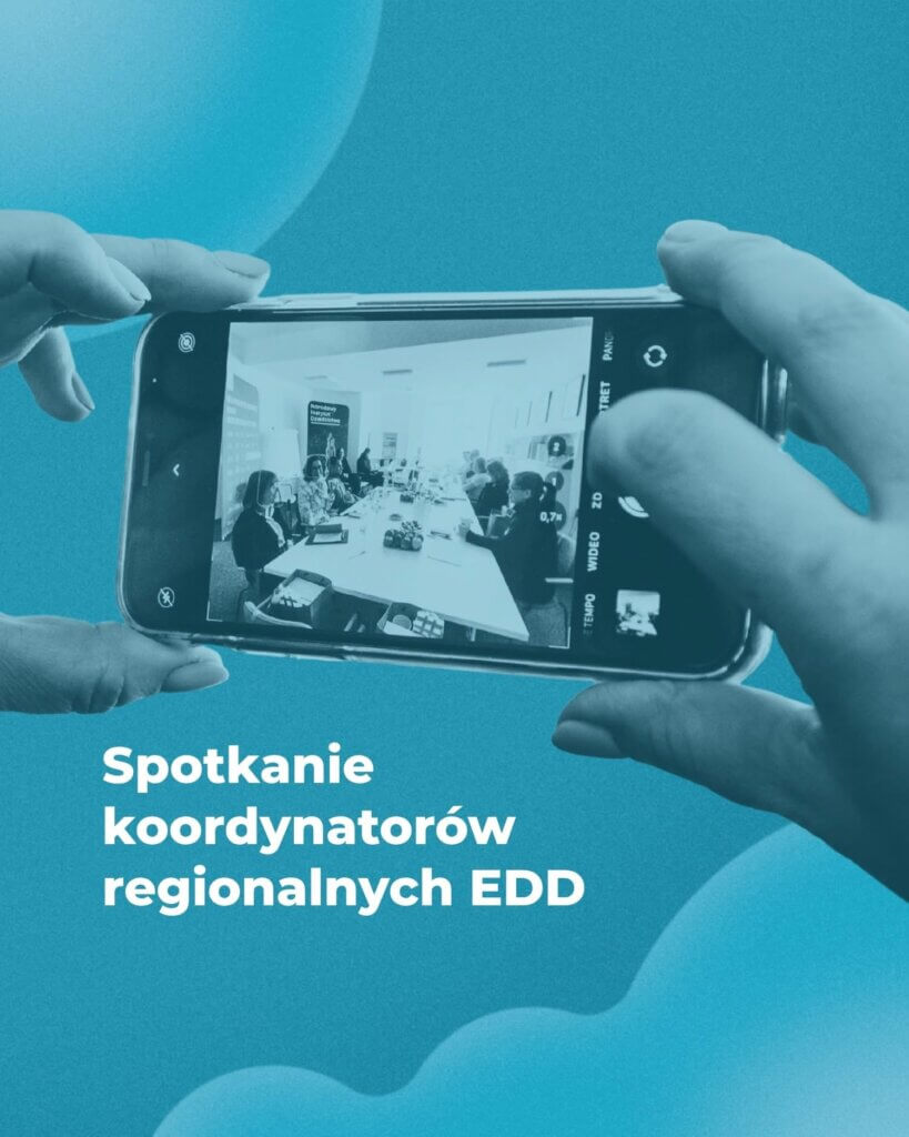Zdjęcie stylizowane na niebiesko przedstawia dłonie trzymające smartfon, na którego ekranie widoczne jest spotkanie kilku osób siedzących przy stole konferencyjnym; na grafice znajduje się napis „Spotkanie koordynatorów regionalnych EDD”.