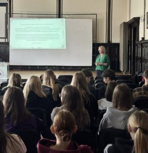 Prowadząca prezentację na tle slajdu dotyczącego procesów o czary na ziemi wschowskiej.